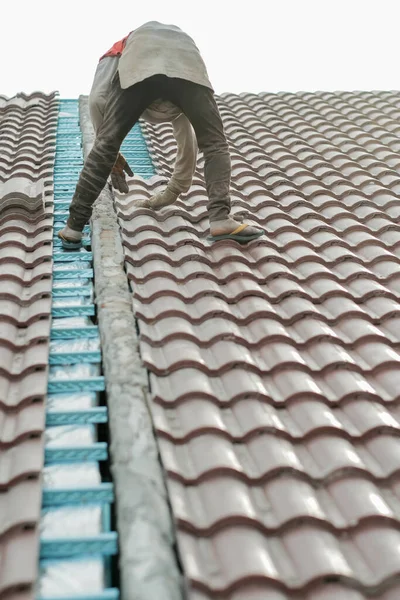 Çatı döşeyen işçiler. Bir ev çatısı, seramik fayans ya da beton çatı döşeme endüstrisi.