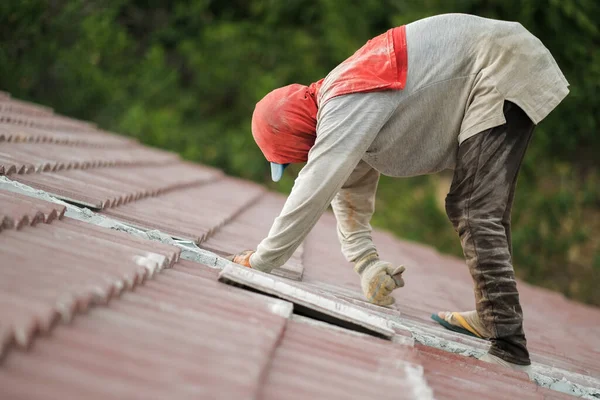 Çatı döşeyen işçiler. Bir ev çatısı, seramik fayans ya da beton çatı döşeme endüstrisi.