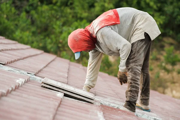 Çatı döşeyen işçiler. Bir ev çatısı, seramik fayans ya da beton çatı döşeme endüstrisi.