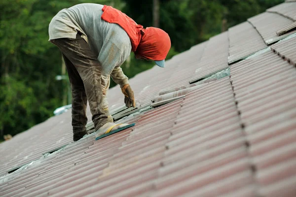 Çatı döşeyen işçiler. Bir ev çatısı, seramik fayans ya da beton çatı döşeme endüstrisi.