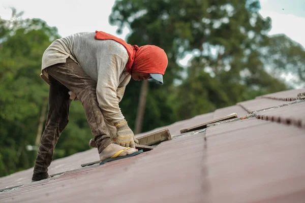 Çatı döşeyen işçiler. Bir ev çatısı, seramik fayans ya da beton çatı döşeme endüstrisi.