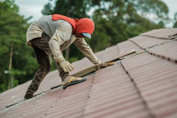 Çatı döşeyen işçiler. Bir ev çatısı, seramik fayans ya da beton çatı döşeme endüstrisi.