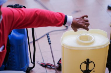 Kuala Lumpur-Malezya - 5 Şubat 2021: Koronavirüs salgınını kontrol altına almak için üniversitede dezenfekte yapan dezenfektan işçisi .