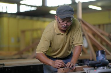 Marangoz yeni bir teras inşa projesinde çatı kirişlerini kuruyor.