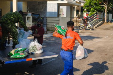 Muadzam Şah, Malezya - 17 Şubat 2021: Covid-19 'un yayılmasını engellemek için Gelişmiş Hareket Kontrol Nişanı (EMCO) altında bulunan Desa Alamanda' da temel gıda tedariklerinin dağıtımı.