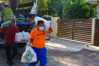 Muadzam Şah, Malezya - 17 Şubat 2021: Covid-19 'un yayılmasını engellemek için Gelişmiş Hareket Kontrol Nişanı (EMCO) altında bulunan Desa Alamanda' da temel gıda tedariklerinin dağıtımı.