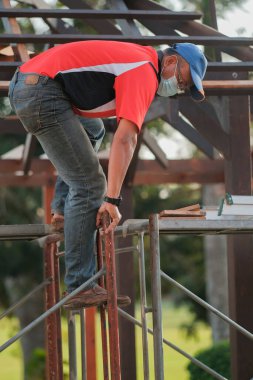 Marangoz yeni bir teras inşaatı projesinde çatı yapısının kurulumunu yapıyor