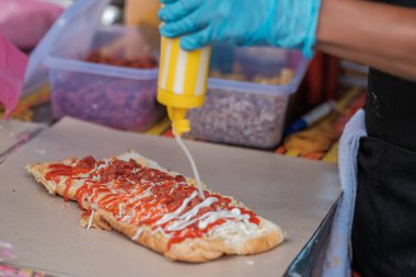 Bir adam, Muadzam Şah 'taki bir ramadhan pazarında John ekmeği veya 