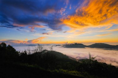 İnanılmaz gün doğumu ve dağlarla dolu bulut.