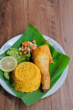 Nasi Arap Mandy ile tavuk Mandy baharatı ve muz yaprağı üzerinde turşu sebze karışımı. Orta Doğu Mutfağı.