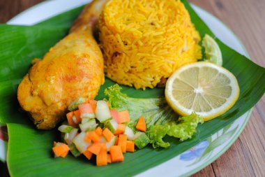 Nasi Arap Mandy ile tavuk Mandy baharatı ve muz yaprağı üzerinde turşu sebze karışımı. Orta Doğu Mutfağı.