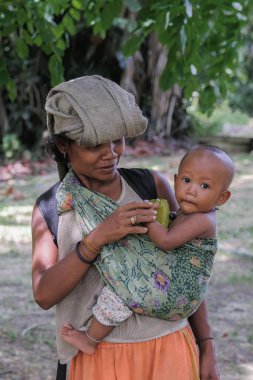 Muadzam Şah, Malezya - 2 Haziran 2021: Güneşli bir günde bebeğini taşıyan Aborjin anne.