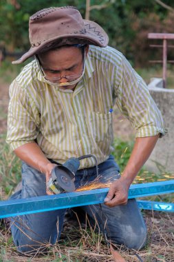 Göz korumalı işçiler, c kanalı çeliğini kesmek için öğütücü kullanıyorlar, endüstriyel işler için araçlar.