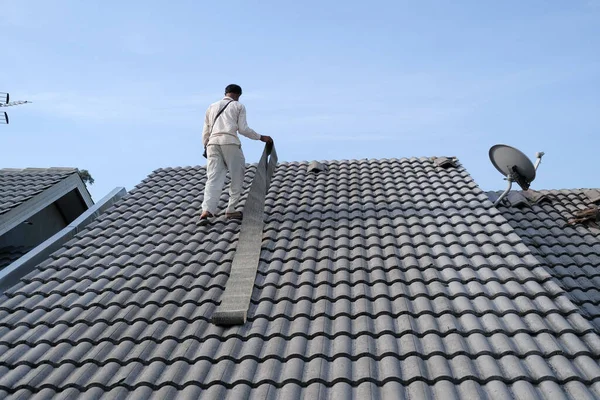 破損した住宅の屋根の上のタイルを修復するとき労働者は個人的な保護具を着用しない — ストック写真