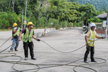 Muadzam Şah, Malezya - 1 Eylül 2021: Telekomünikasyon İnternet sağlayıcısı firmasından işçiler fiber optik kabloların uygulanması üzerinde çalışıyorlar .