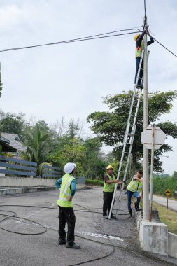 Muadzam Şah, Malezya - 1 Eylül 2021: Telekomünikasyon İnternet sağlayıcısı firmasından işçiler fiber optik kabloların uygulanması üzerinde çalışıyorlar .