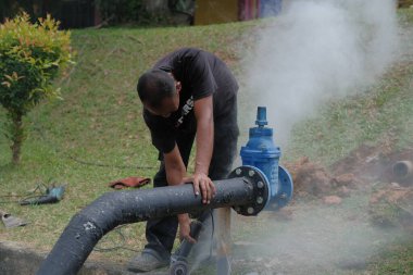 Muadzam Shah, Malezya - 1 Eylül 2021: Tesisatçı, ana drenajda yeni HDPE çalışmaları için öğütücü makine kullanıyor