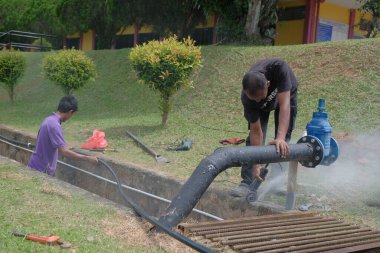 Muadzam Shah, Malezya - 1 Eylül 2021: Tesisatçı, ana drenajda yeni HDPE çalışmaları için öğütücü makine kullanıyor