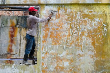 Yıkım işleri ve yeniden düzenleme. Balyozlu işçi duvarı yıkıyor.