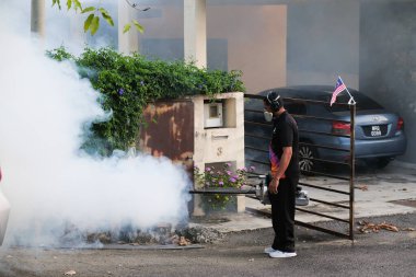 Malezya - 20 Eylül 2021: İşçi yerleşim alanını böcek ilaçlarıyla kaplayan işçiler