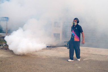 Malezya - 20 Eylül 2021: İşçi yerleşim alanını böcek ilaçlarıyla kaplayan işçiler