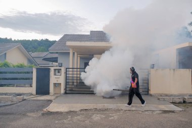 Malezya - 20 Eylül 2021: İşçi yerleşim alanını böcek ilaçlarıyla kaplayan işçiler