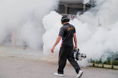 Malezya - 20 Eylül 2021: İşçi yerleşim alanını böcek ilaçlarıyla kaplayan işçiler