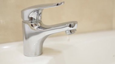 Banyodaki musluktan su damlıyor.