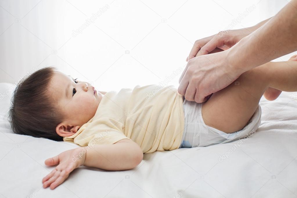 One samiling little baby girl change diaper isolated on white with father's hand