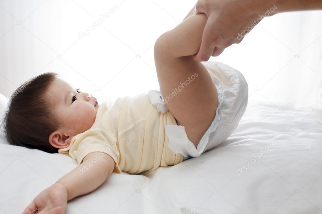 One samiling little baby girl change diaper isolated on white with father's hand