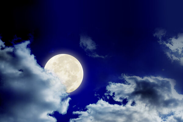 Big full moon and clouds in dark sky, the moon is behind the cloud