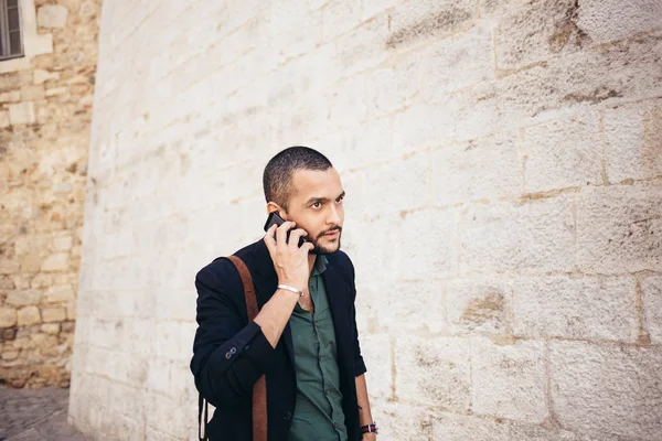 Portrait of young bearded man talking on his phone — Stock Photo, Image