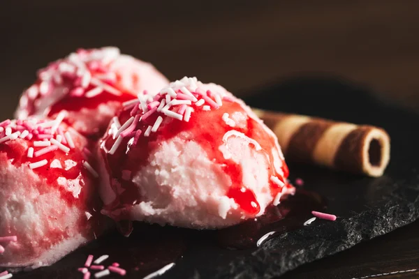 Pink ice cream balls covered with strawberry syrup — Stock Photo, Image