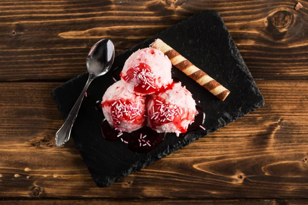 Bolas de helado rosa cubiertas con jarabe de fresa — Foto de Stock