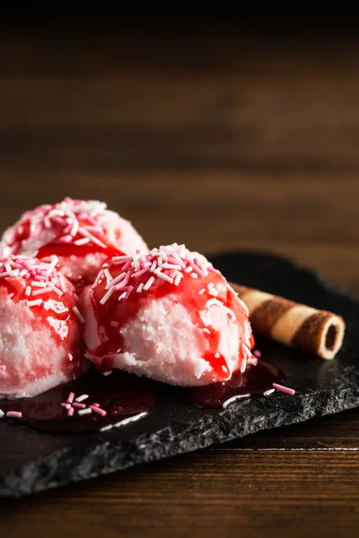 Bolas de helado rosa cubiertas con jarabe de fresa — Foto de Stock