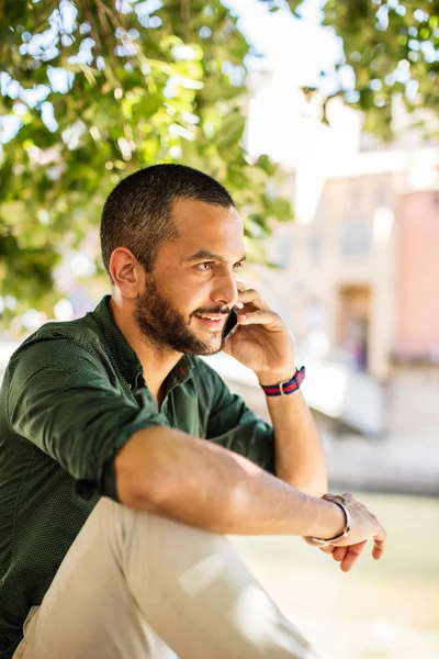 Vista lateral de homem barbudo conversando sobre seu telefone — Fotografia de Stock