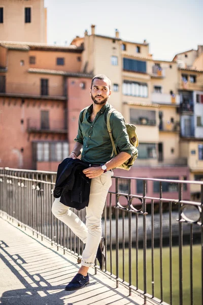 Bearded traveller leaning on parapet and looking away — Stock Photo, Image