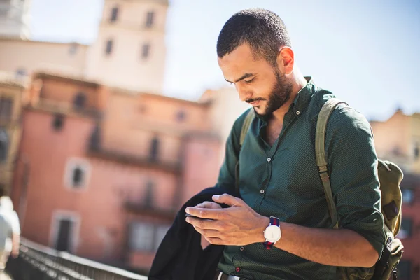 Ung skäggiga resenär som använder sin smartphone — Stockfoto
