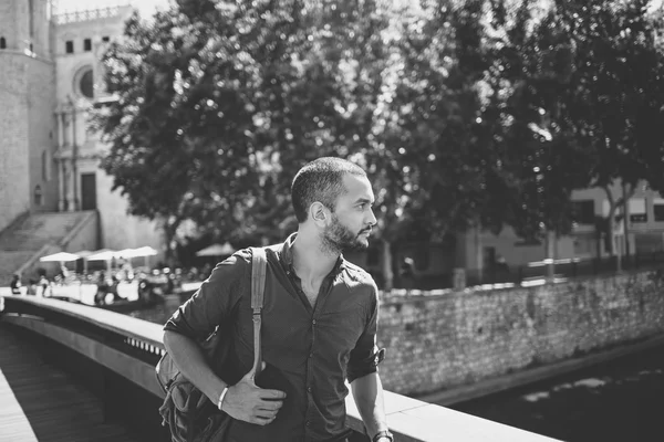 Handsome bearded man walking on bridge and looking away — Stock Photo, Image