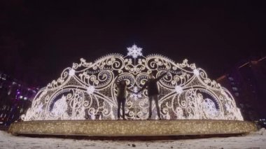 Birbirine aşık çiftler kameraya bakar ve yeni yılda öpüşürler. arkaplan Noel dekorasyonu