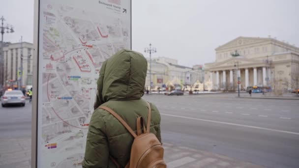 Touriste fille dans le centre-ville regarde une carte. toile de fond d'un grand théâtre Clip Vidéo