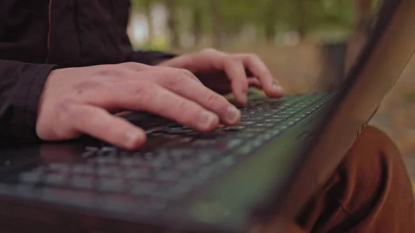 Moving Macro Shot: Person Typing på Computer Keyboard. Jobbe, skrive e-post, bruke Internett. Notatbok på tavlen, lystig solskinnsdag i bakgrunnen – stockfoto