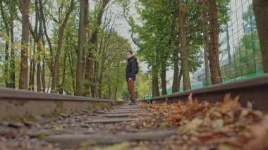 18 yaşında, modern, kalın giysiler içinde omuzlarında sırt çantasıyla pistte yürüyen yakışıklı bir genç adam, kameranın odağı bozuk. Gençlik yalnızlığı kavramı, dünyada bir tane.