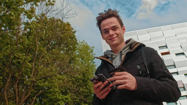 Jeune homme, adolescent. Fait votre premier achat en ligne. Client masculin tenant carte de crédit et smartphone, sur fond de maison moderne. Garçon heureux acheteurs utilisant des paiements mobiles simples instantanés tout en — Photo