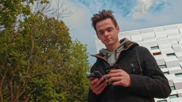 Junger Mann, Teenager. Machen Sie Ihren ersten Online-Kauf. Männlicher Kunde mit Kreditkarte und Smartphone, auf modernem Hintergrund zu Hause. Glückliche Käufer mit sofortigem, einfachem mobilen Bezahlen, während — Stockvideo