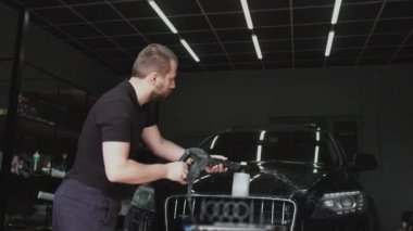 Adam arabayı jet suyla çalkaladı ve oto yıkamada yüksek basınçlı köpükle yıkadı.