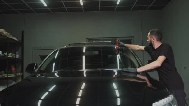 Profissional Car Cerâmica Trabalhador aplica uma camada de cerâmica capa de chuva protetora nas janelas do carro. Conceito de: Proteção Nano, Acessórios diferentes, Proteção longa — Vídeo de Stock