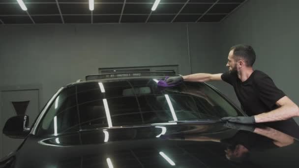 Profissional Car Cerâmica Trabalhador aplica uma camada de cerâmica capa de chuva protetora nas janelas do carro. Conceito de: Proteção Nano, Acessórios diferentes, Proteção longa — Vídeo de Stock