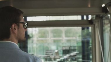 Genç bir işadamı, büyük bir şirketin çalışanı modern, güzel bir ofiste yürüyor ve selamlıyor, elini sallıyor. Elleri kapalı ateş ediyorlar. Başarılı bir çalışan konsepti.