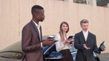 Genç yakışıklı bir adam iki iş adamı, bir kadın ve bir erkek için bir tablette sunum yapıyor. Öğle yemeği için ofisin yakınında çekim. Her yerde çalışan çok meşgul iş adamları kavramı. Halkı